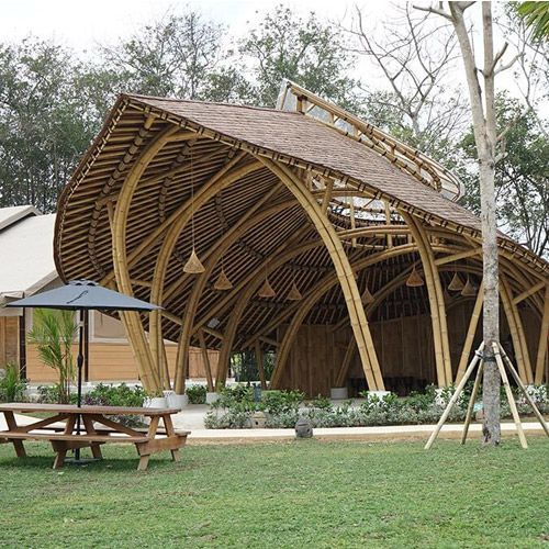 a large wooden structure sitting on top of a lush green field