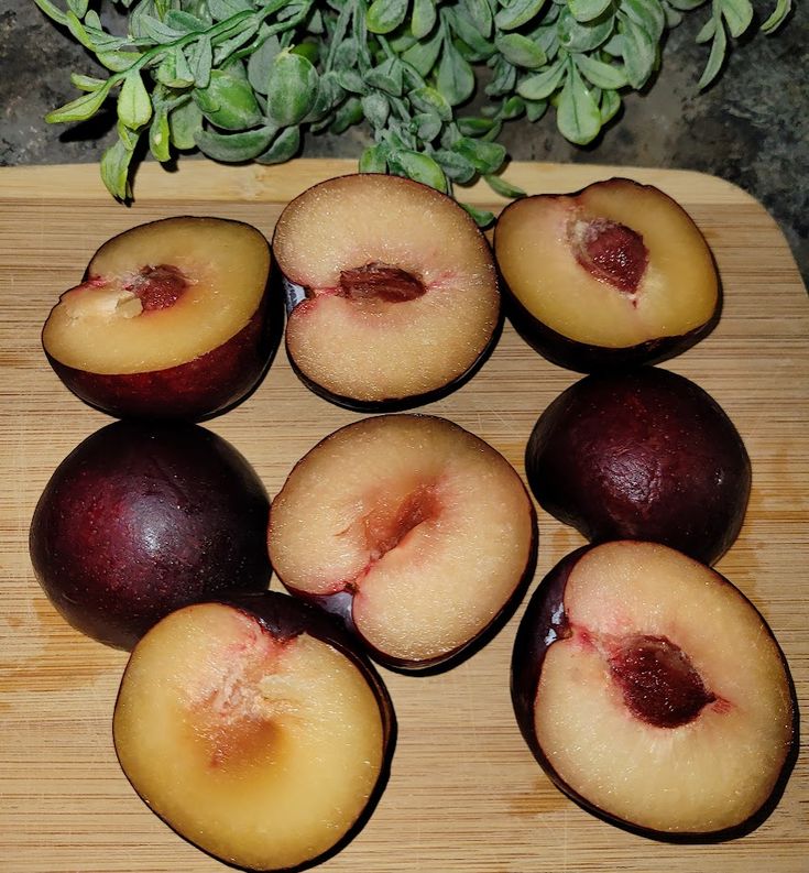 some plums are sitting on a cutting board