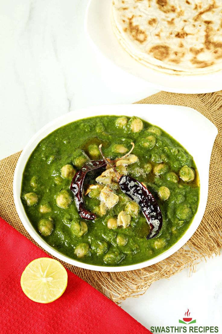 chickpeas in spinach gravy served in a white bowl on a red napkin