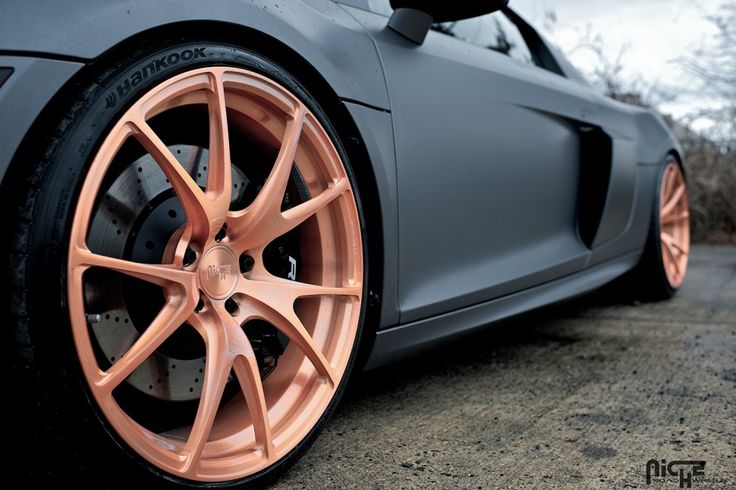 an orange rim on a grey sports car