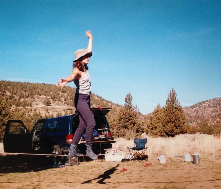 a woman is standing on the back of a pickup truck with her arms in the air