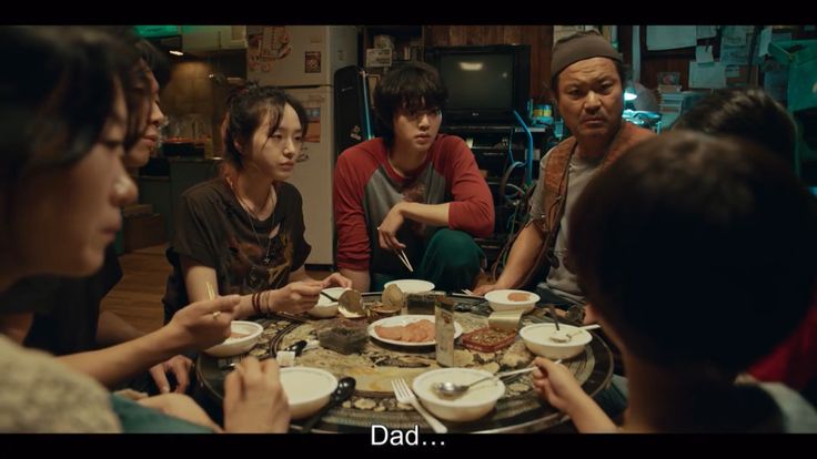 a group of people sitting around a table eating food