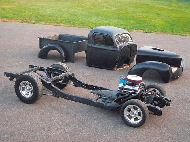 an old car is parked in the parking lot next to other antique cars and trucks