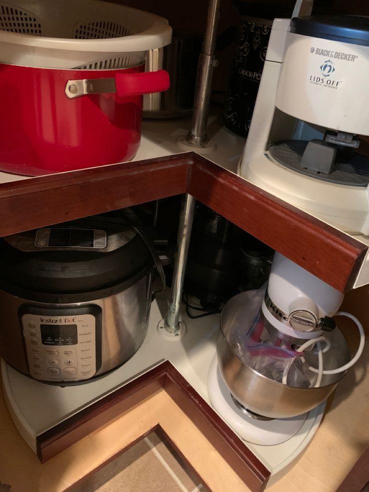 a kitchen counter with two crockpots and an electric mixer