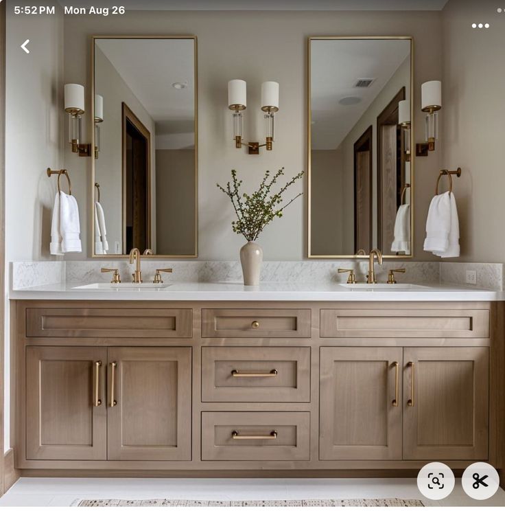 a bathroom with two sinks, mirrors and lights on the wall next to each other