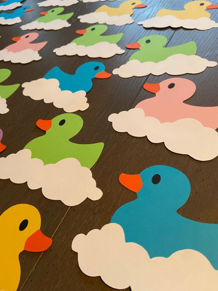 colorful rubber ducks sitting on top of a wooden floor with white clouds in the background