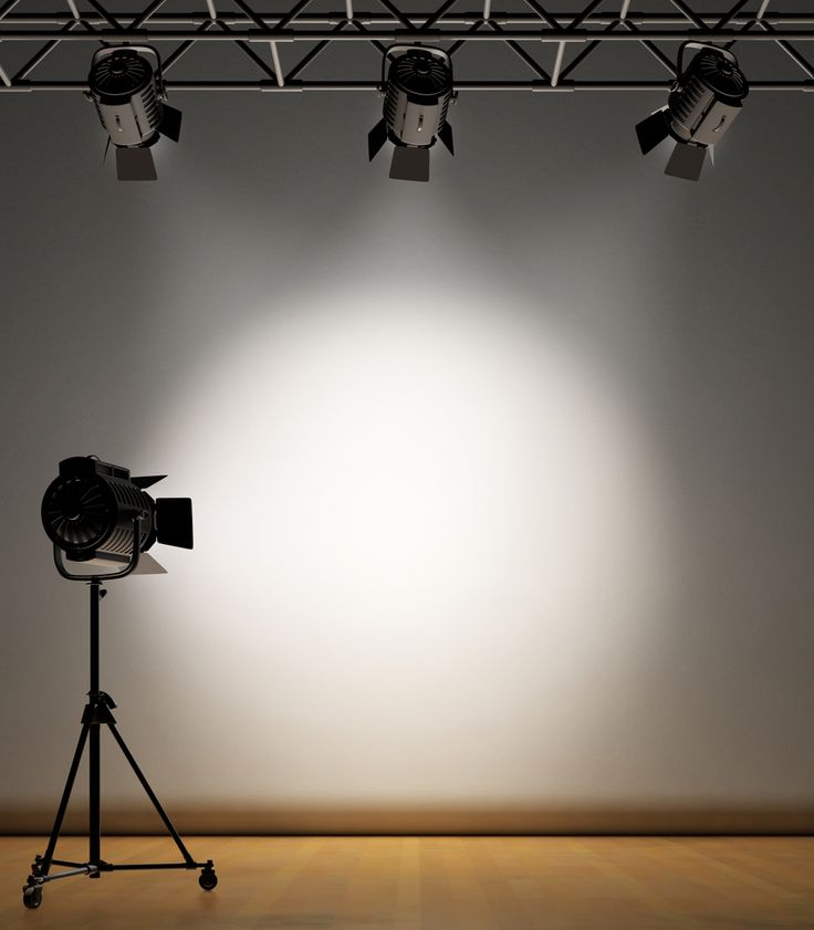 an empty room with three spotlights and a tripod in front of the camera