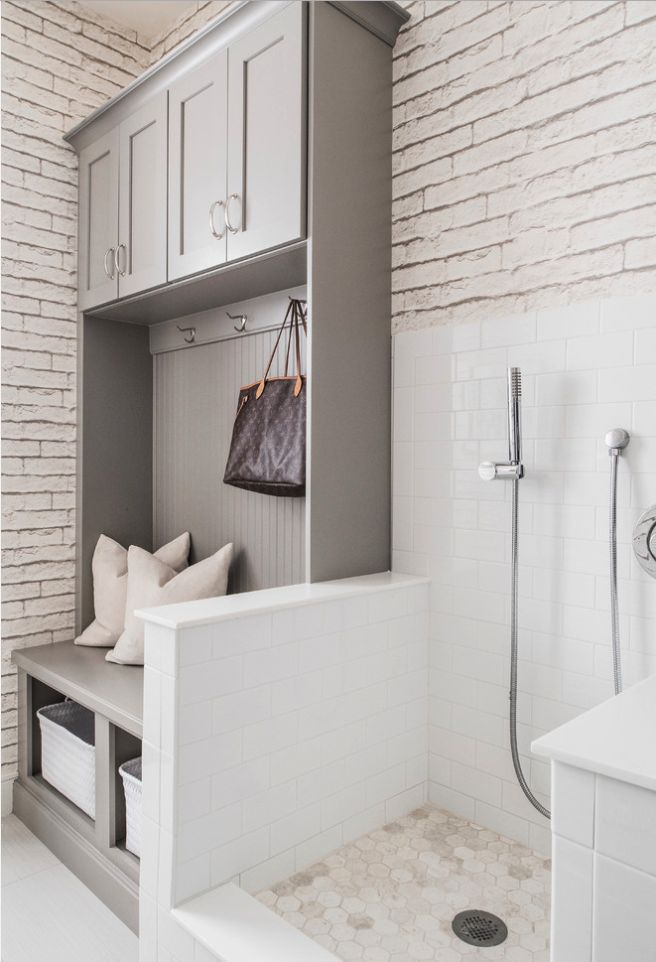 an instagramted photo of a bathroom with white cabinets and gray accents, including a bench