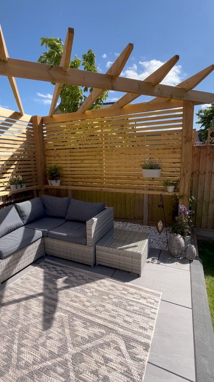 an outdoor living area with couches and wooden pergols