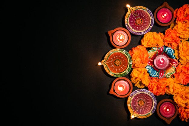 an arrangement of candles and flowers on a black background