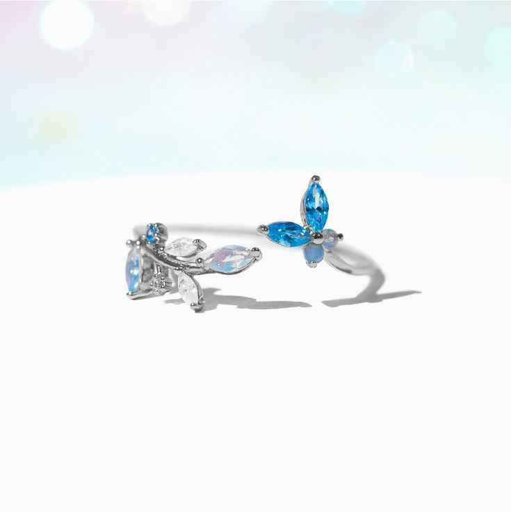 This ring is oh, so perfect. From the radiant array of blue crystals to the adjustable nature of the band, this ring has so many elements that only adds to it's elegance. Featuring a string of leaves on one end and a cute little butterfly on the other, our Perfect Petal Ring is just the piece to add to your garden of jewels. Elegant Adjustable Blue Flower Ring, Elegant Blue Adjustable Flower Ring, Adjustable Crystal Ring For Gift, Adjustable Light Blue Sterling Silver Rings, Adjustable Blue Crystal Promise Ring, Adjustable Blue Crystal Wedding Ring, Blue Adjustable Crystal Promise Ring, Blue Adjustable Crystal Wedding Ring, Blue Crystal Wedding Ring