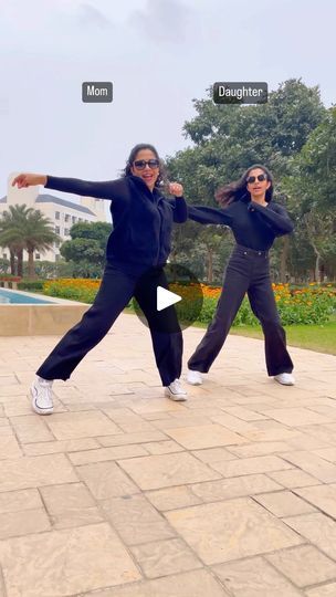 two women are dancing in front of a pool