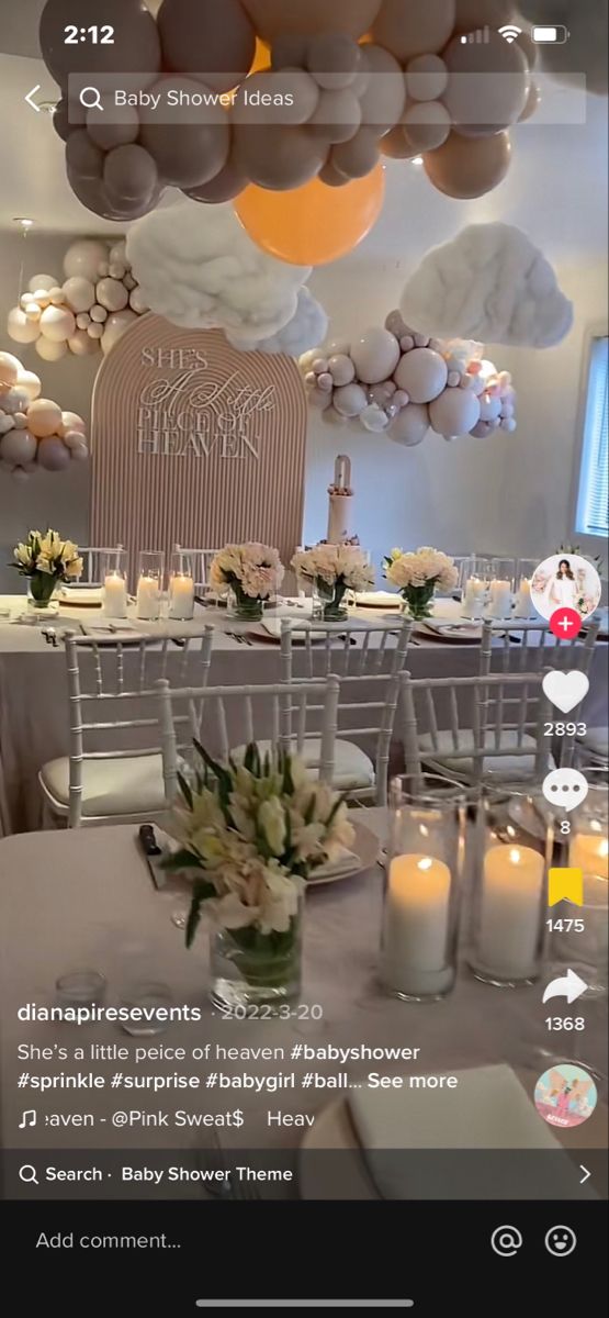 the table is set for a baby shower party with balloons and flowers in vases