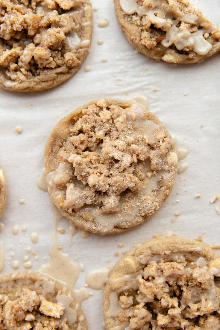 several cookies with crumbs and icing sitting on top of a baking sheet