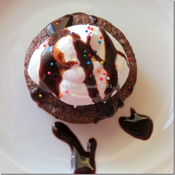 an ice cream sundae with chocolate sauce and sprinkles on a white plate