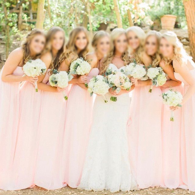 a group of women standing next to each other holding bouquets