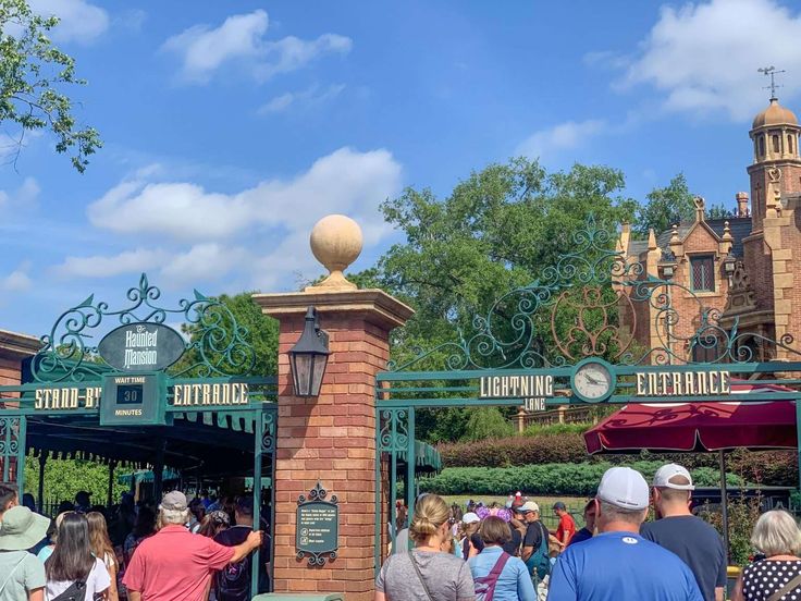 the entrance to disneyland california adventure park with people walking around and onlookers