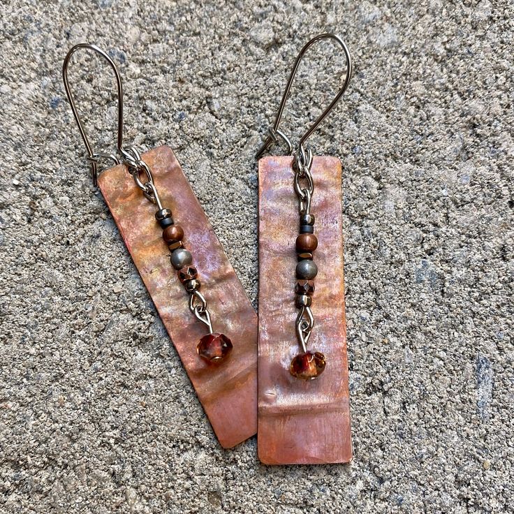 "These copper earrings are one of a kind.  Each piece was hand cut, filed and flame-torched resulting in a unique pattern and gorgeous color. The most amazing thing is the colors & patterns change depending on the light source. Earrings are embellished with a variety of beads. Each piece was clear-coated to help preserve color.  Materials: Copper/Nickel Free Earwire Color: Copper/Silver Measurements: Rectangle Charm 1 3/4\" x 1/2\"...Drop length approx. 2 1/2\" Weight : 3 grams/.07 oz. (individu Pebble Jewelry, Metal Jewelry Making, Hammered Bracelet, Beachglass Jewelry, Upcycled Jewelry, Ear Rings, Creative Jewelry, Wire Earrings, Copper Earrings