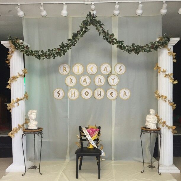 a baby shower is set up in front of a white backdrop with gold trimmings