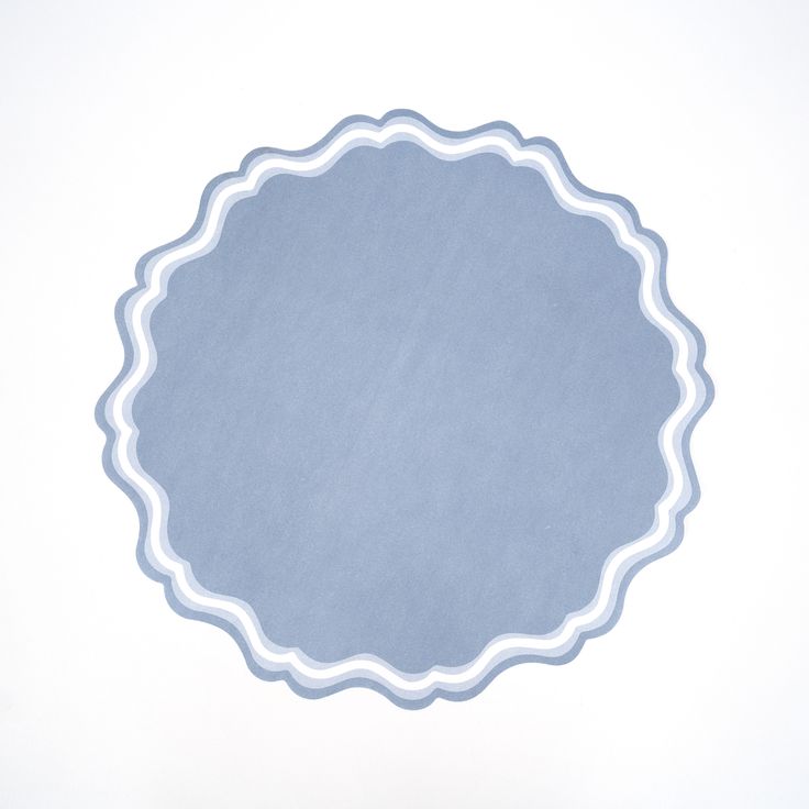 an empty blue plate with white trim around it on a white surface in front of a plain background