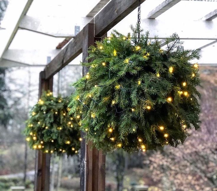 two wreaths hanging from the ceiling with lights on them