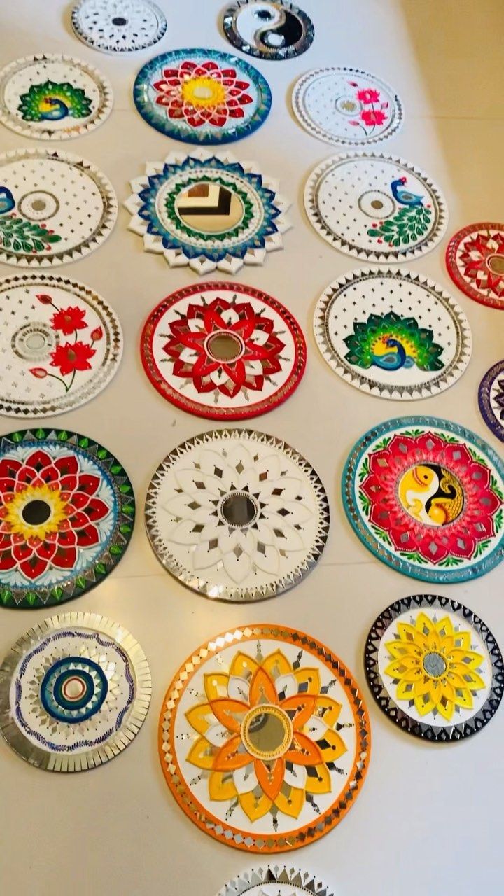 a table topped with lots of colorful plates on top of a white counter covered in designs