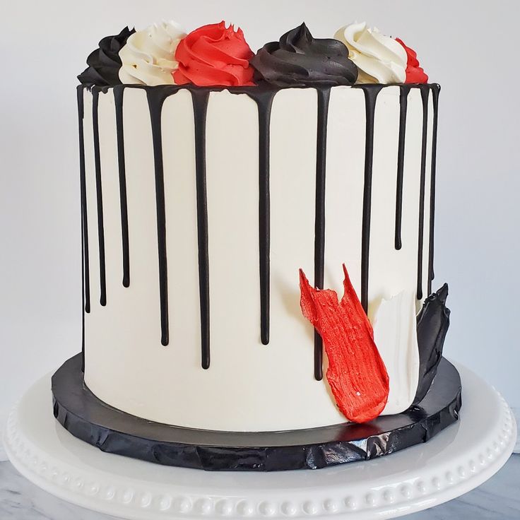 a white and black cake with red icing