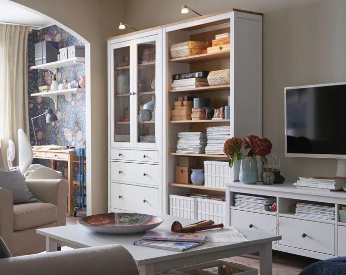 a living room filled with furniture and a flat screen tv on top of a wooden shelf