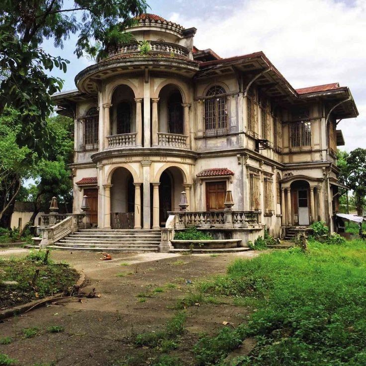 an old, run down house with lots of windows and balconies on the second floor