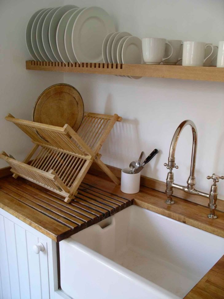 a kitchen with white dishes and wooden shelves