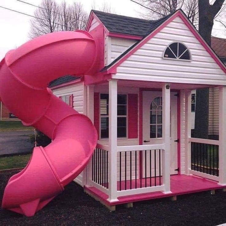 a pink slide in front of a white house