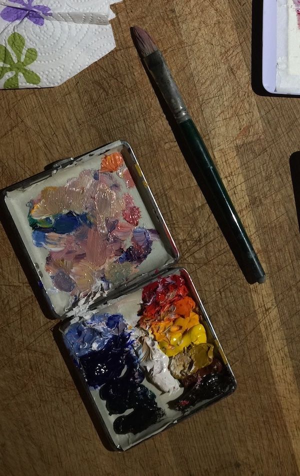 an artist's palette and brush on a wooden table