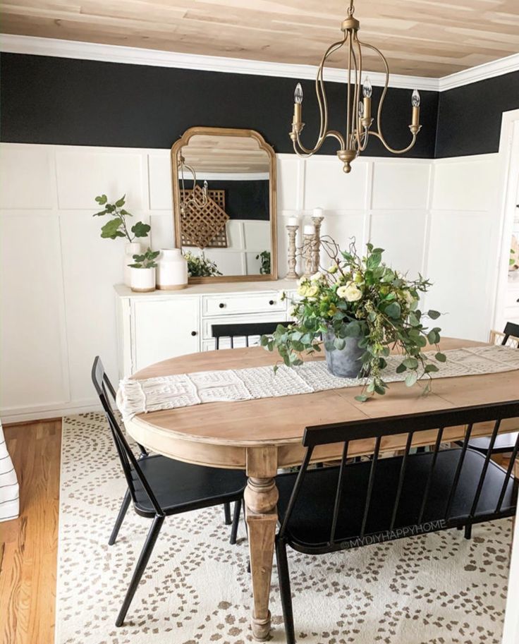 a dining room table with black chairs and white walls