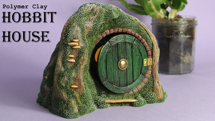 a green hobbit house sitting next to a potted plant