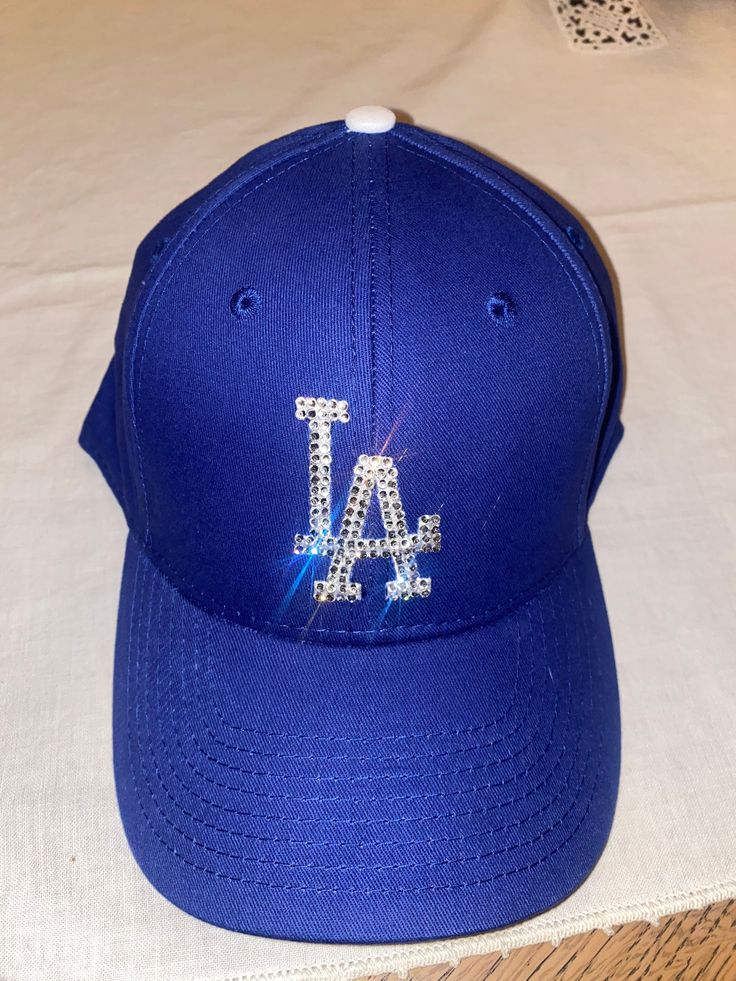 Los Angeles dodgers hat embellished with crystals. Embellished Adjustable Hat With Curved Brim, Adjustable Baseball Cap With Bling, Adjustable Rhinestone Baseball Cap With Curved Brim, Rhinestone Baseball Cap One Size, Rhinestone Embellished One Size Baseball Cap, Blue Adjustable Hat With Rhinestones, Adjustable Blue Hat With Rhinestones, Adjustable Rhinestone Cap, Dodger Hat