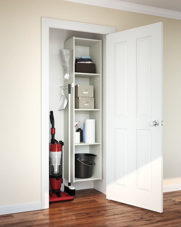 an open white door in a room with hard wood flooring and shelves on either side