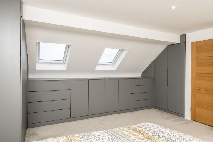 an empty room with two skylights above the windows and cupboards on the wall