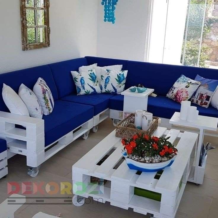 a living room with blue couches and white tables