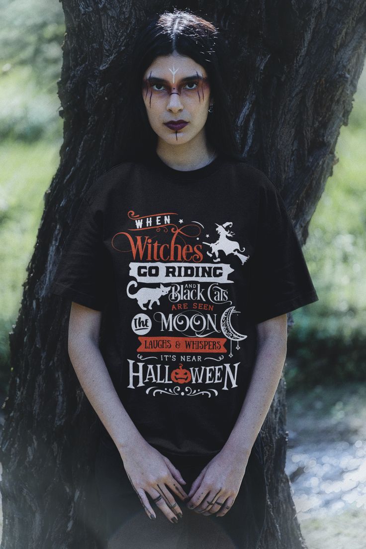 When Witches go Riding and Black Cats are seen, The Moon Laughs and Whispers, It's Near Halloween! This soft and fun unisex t-shirt makes for the perfect Halloween celebration. Get yours today! Shop our whole Halloween collection here! Soft and light feel with just the right amount of stretch. Comfortable and flattering with a tear away tag for added comfort. Pre-shrunk before printing. Find our Size Charts HERE! Solid colors are 100% Airlume combed and ring-spun cotton (Heather colors are 52% c Black Slogan T-shirt For Fall, Black Halloween T-shirt With Text Print, Spooky Black T-shirt With Screen Print, Black Slogan T-shirt For Halloween, Black Novelty Short Sleeve Tops, Black Short Sleeve Novelty Top, Black Spooky T-shirt With Funny Print, Spooky Black T-shirt With Funny Print, Novelty Black Tops With Funny Text