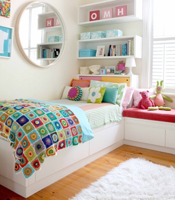 a child's bedroom with white walls and wooden floors, decorated in bright colors