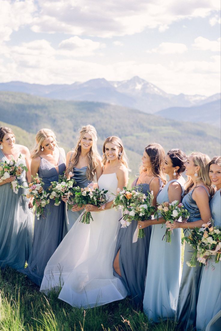 a group of women standing next to each other on top of a lush green field