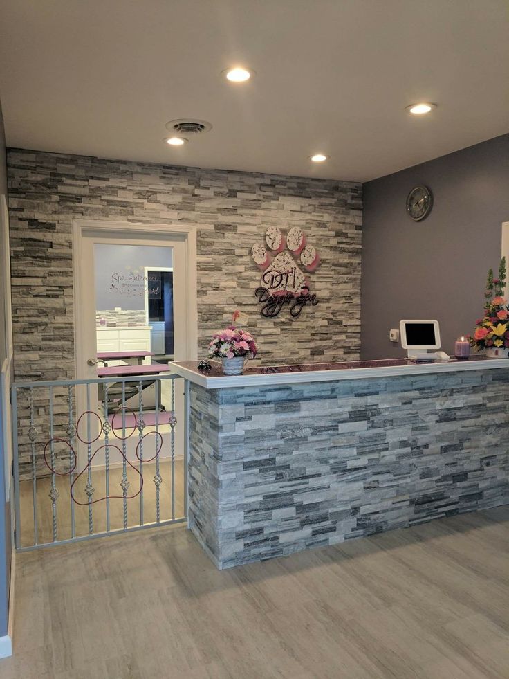 a reception area with stone wall and metal railing