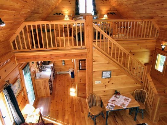 an aerial view of a living room and dining area in a log cabin style home