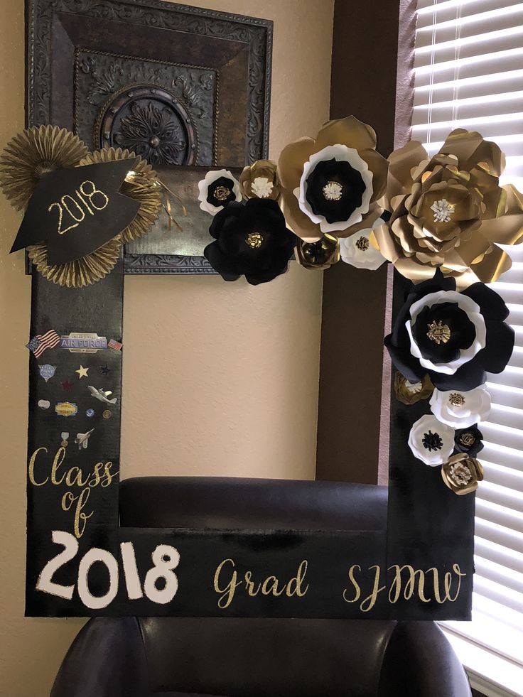 a black and gold class of 2018 graduation photo frame with flowers on it in front of a window