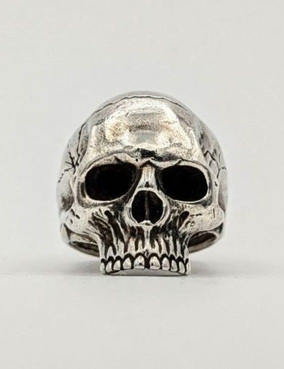 a silver skull ring with black eyes