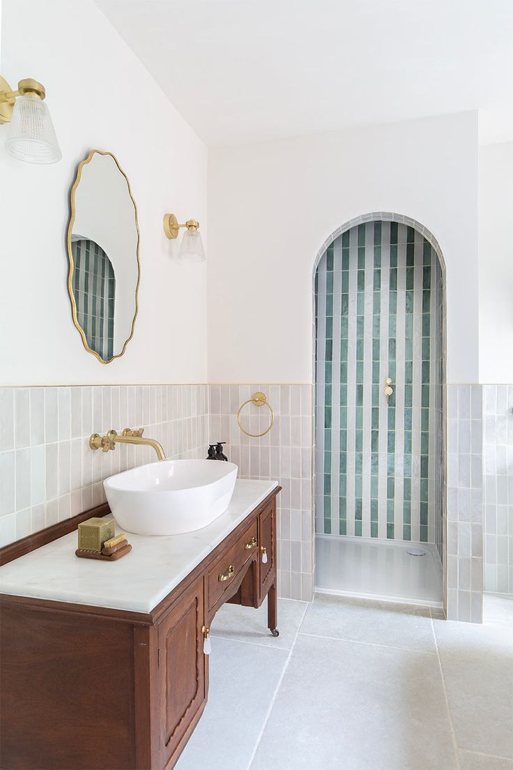 a bathroom with two sinks and a large mirror above the sink, along with an arched doorway