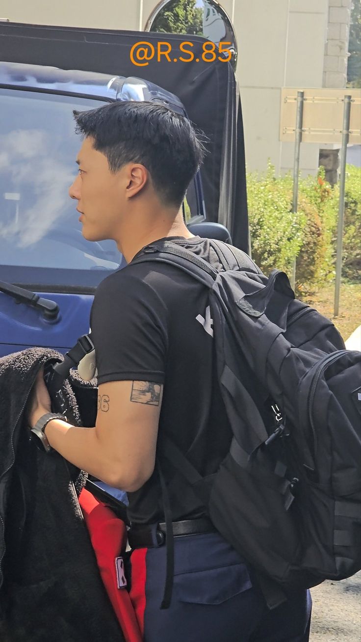 a man with black hair carrying a backpack