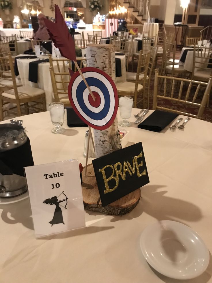 the table is set up for an event with place cards and signs on it,