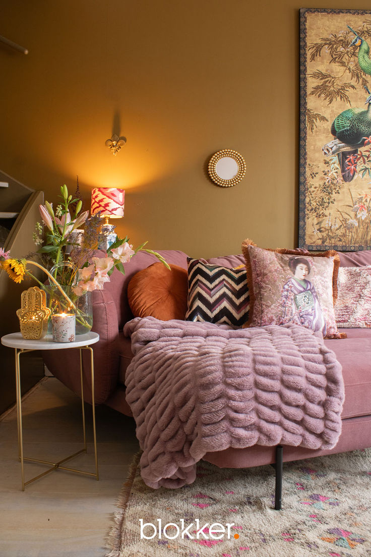 a living room with a pink couch and pillows