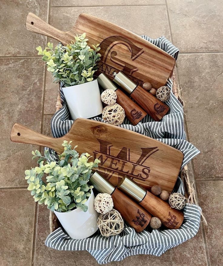 two wooden utensils are sitting in a basket on the floor next to some succulents